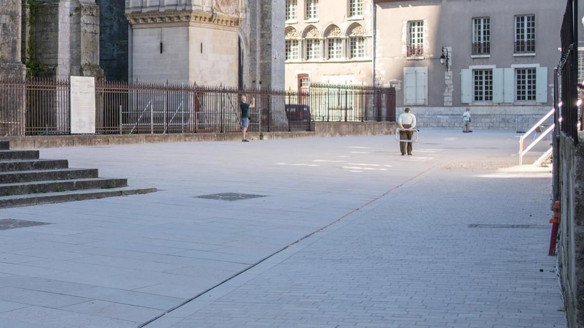 Au portail Nord de la cathédrale, la jonction entre grandes dalles, côté cathédrale, et petites dalles en périmètre extérieur, rend visible le principe de réaménagement. Photo prise en juin 2024. 