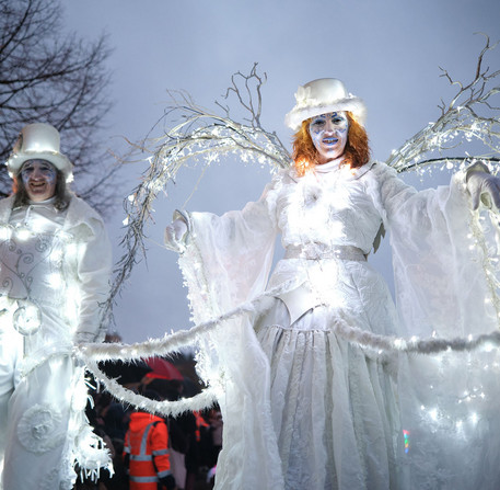 Des animateurs de No&euml;l sur des &eacute;chasses avec leur costumes de lumi&egrave;re devant le public, &agrave; Chartres.
