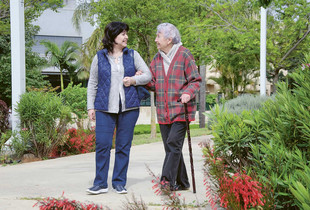 Bénévole accompagnant une personne âgée lors d'une promenade