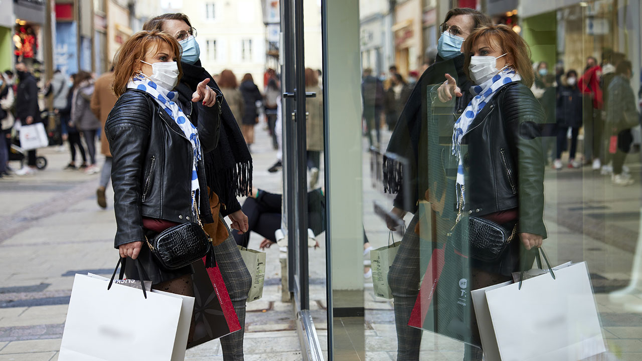Femmes portant des sacs et regardant une vitrine dans le centre-ville de Chartres