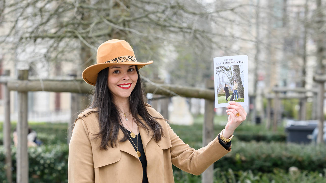 Sophie Beurel tenant le guide de l'animal en ville dans la main