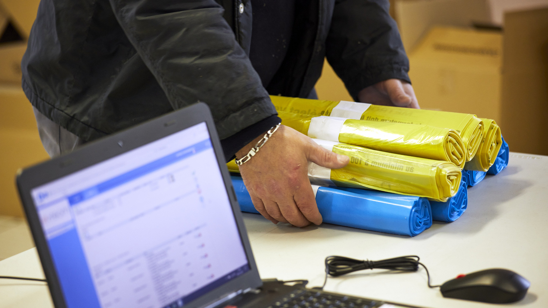 Personne recevant des sacs-poubelle gratuits dans un point de distribution